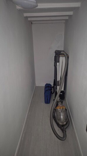 A narrow hallway with a vacuum cleaner and a blue bag. - Cool, Calm Georgian Apartment base in Shrewsbury -pet friendly (Shrewsbury)