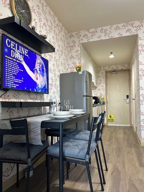 A modern kitchen with a dining area, a TV displaying Celine Dion's greatest hits, and a 'KEEP AREA CLEAN' sign. - Family Condo SMB-Live, Love & Laugh with amazing place to stay & visit. (Pasay City)