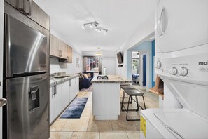 A modern kitchen with stainless steel appliances, a central island, and a built-in oven. - Comfort By The Sea (Roatan)