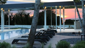 A modern outdoor pool area with lounge chairs and a pergola structure. - Villa Calvia Crispinilla by Villas Guide (Novigrad)