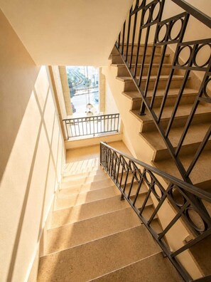 Eine Treppe mit Metallgeländer und Blick ins Freie.