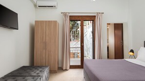 Un dormitorio con cama, armario, banca y televisor.