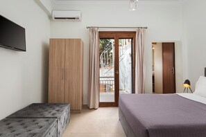 Ein Schlafzimmer mit Bett, Kleiderschrank, Bank und Fernseher.