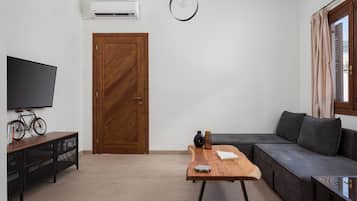 Suite, balcón | Zona de estar | Televisión de pantalla plana de 30 pulgadas con canales por cable