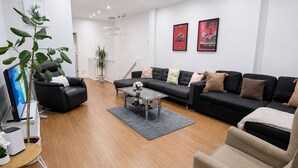 Una sala de estar moderna con un conjunto de sofá, una mesa de centro y un televisor.