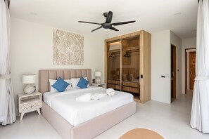 Ein Schlafzimmer mit einem Bett, Nachttischen, einem Deckenventilator, einem Kleiderschrank und einem großen Kunstwerk an der Wand.