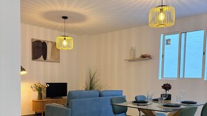 A modern living room with a sofa, dining table, chairs, and a TV. - 3 Bedrooms by Ruzafa, metro 1 min, A/C (València)