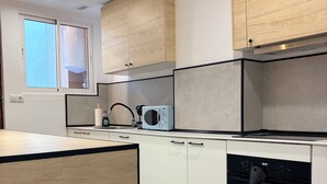 A modern kitchen with wooden cabinets, a built-in microwave, and a dishwasher. - 3 Bedrooms by Ruzafa, metro 1 min, A/C (València)