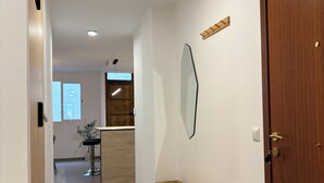 A hallway with a wooden bench, a door, and a mirror on the wall. - 3 Bedrooms by Ruzafa, metro 1 min, A/C (València)