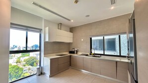Una cocina moderna con un gran ventanal, estufa integrada y un fregadero.