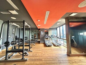 A gym with weightlifting equipment, treadmills, and large windows. - Cozy 2-Bedroom Apartment in Victoria Island, Lagos. (Lagos)