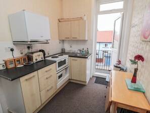 Eine kleine Küche mit Herd, Toaster und Schränken.