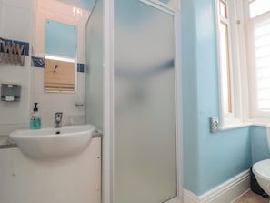 A bathroom with a sink, mirror, and shower. - Meltham Guest House (Scarborough)