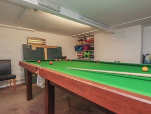 A pool table with balls, a chair, and a shelf with toys. - Meltham Guest House (Scarborough)