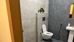A bathroom with a toilet, bidet, and sink. - Hotel Shri Radhavan (Mathura)