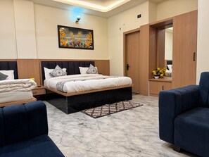 Un dormitorio moderno con cama, dos mesitas de noche, cómoda, espejo y zona de estar.