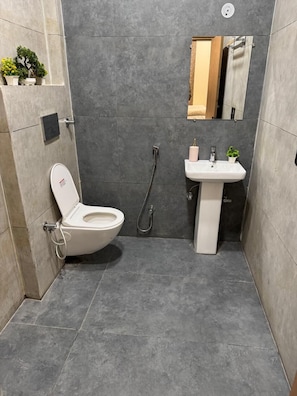 Un baño con inodoro, lavabo y ducha.
