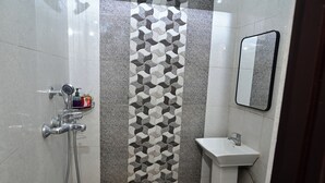Baño con ducha, lavamanos e inodoro.