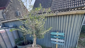 Ett vågplåtsförråd med en skylt som visar vägen till en ateljé, ett plantskolan, ett torkställ och en plats som heter Poitier.