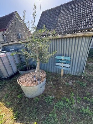 A corrugated metal shed with a sign indicating directions to an Atelier, a Pepiniere, a Gerbe, and a Poitier.