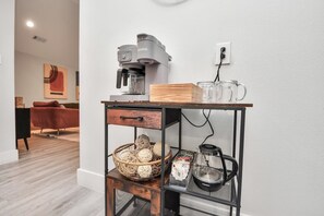 Eine Küchenzeile mit einer Kaffeemaschine, einem Wasserkocher und einem Korb voller Eier.