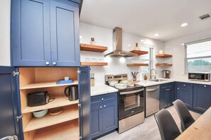 A modern kitchen with blue cabinets, a built-in oven, and a microwave. - 3BR w loft | Near I MDanderson l TMC, UH & NRG (Houston)