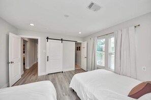 A bedroom with two beds, a sliding door, and a window with curtains. - 3BR w loft | Near I MDanderson l TMC, UH & NRG (Houston)