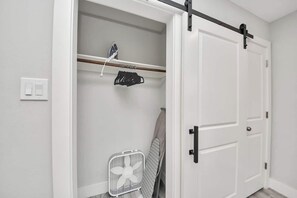 A white closet with a sliding door, a hanging rack, and a fan. - 3BR w loft | Near I MDanderson l TMC, UH & NRG (Houston)