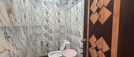 Un baño con inodoro, lavamanos y una puerta decorativa.