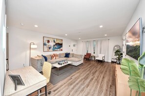 Un salon moderne avec un canapé, une table basse et un bureau avec une chaise.