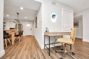 Eine moderne Küche mit einem Edelstahl-Kühlschrank, Holzschränken und einem Essbereich mit Holztisch und -stühlen.