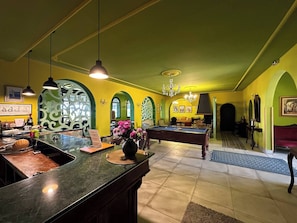 A pool table in a room with green walls and a bar area. - Grotte de Sel Private Pool (Ghar El Melh)