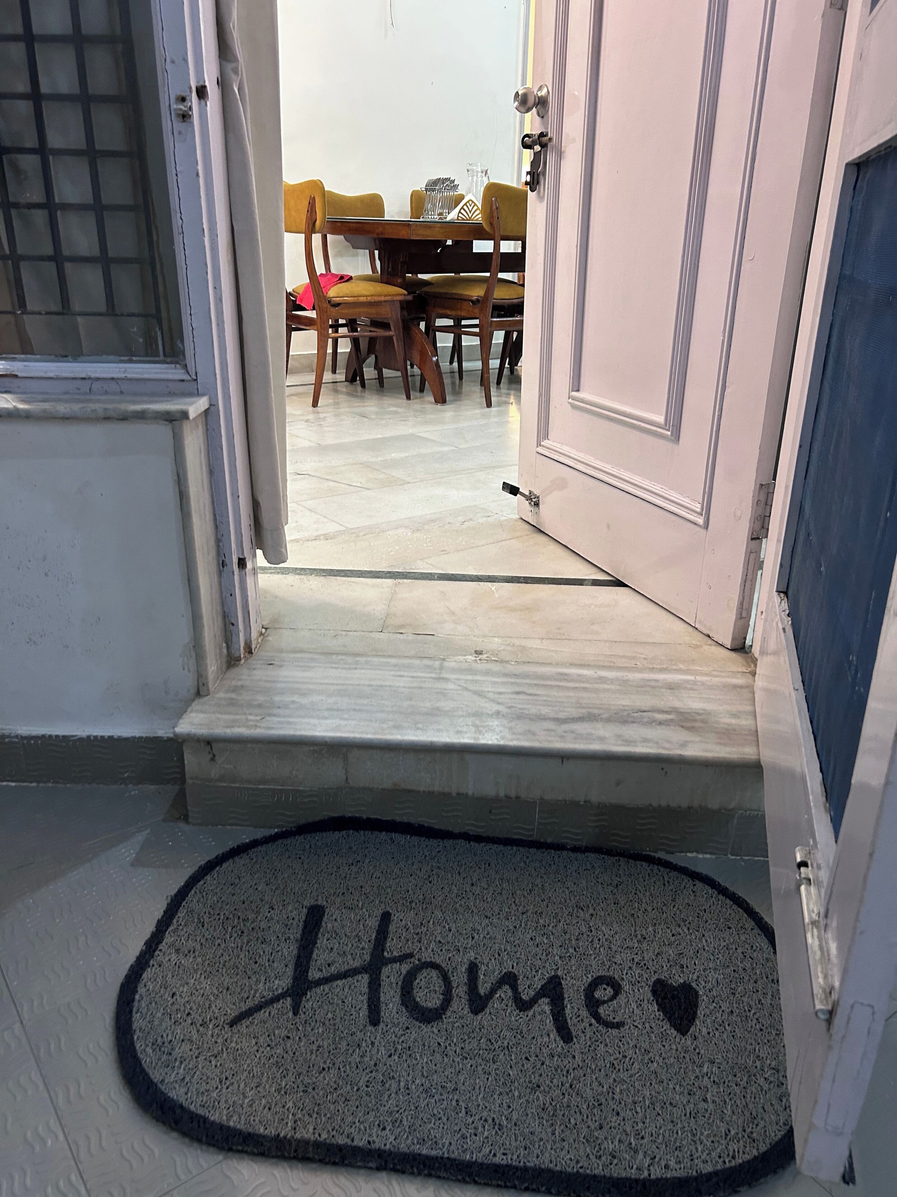 A doorway leading to a dining area with a table and chairs.