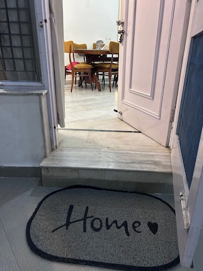 A doorway leading to a dining area with a table and chairs. - Charming Bungalow Rental in Jammu (Jammu)