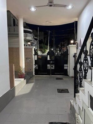 A gated entrance with a ceiling fan, a staircase, and a potted plant. - Charming Bungalow Rental in Jammu (Jammu)