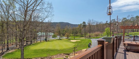 A golf course with a wooden deck overlooking the fairway.
