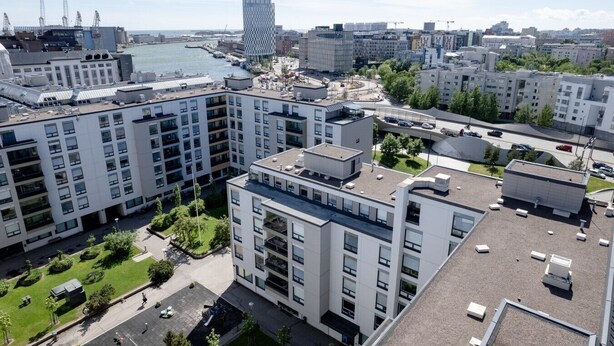 A high-rise residential building with multiple balconies, a waterfront view, and a modern architectural style. - Premium 3BR Home | Prime Location | Modern Touch (Helsinki)
