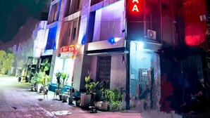 A multi-story hotel with a prominent neon sign on the facade. - Hotel Menkaa (Patna)