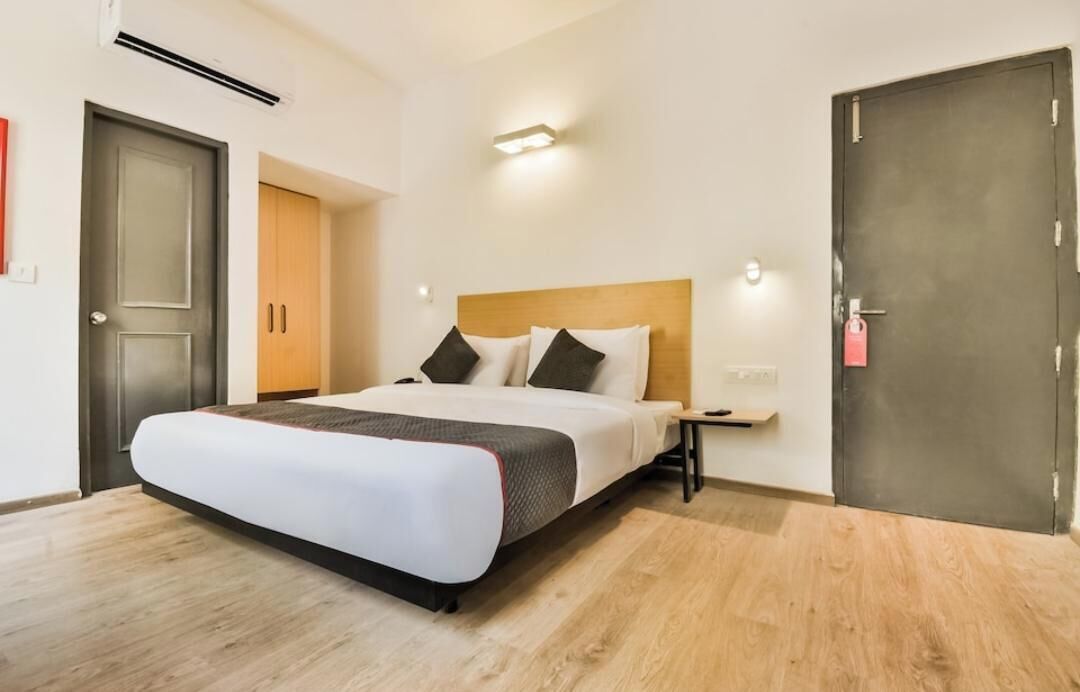 Et hotelværelse med en seng, et natbord og en dør.