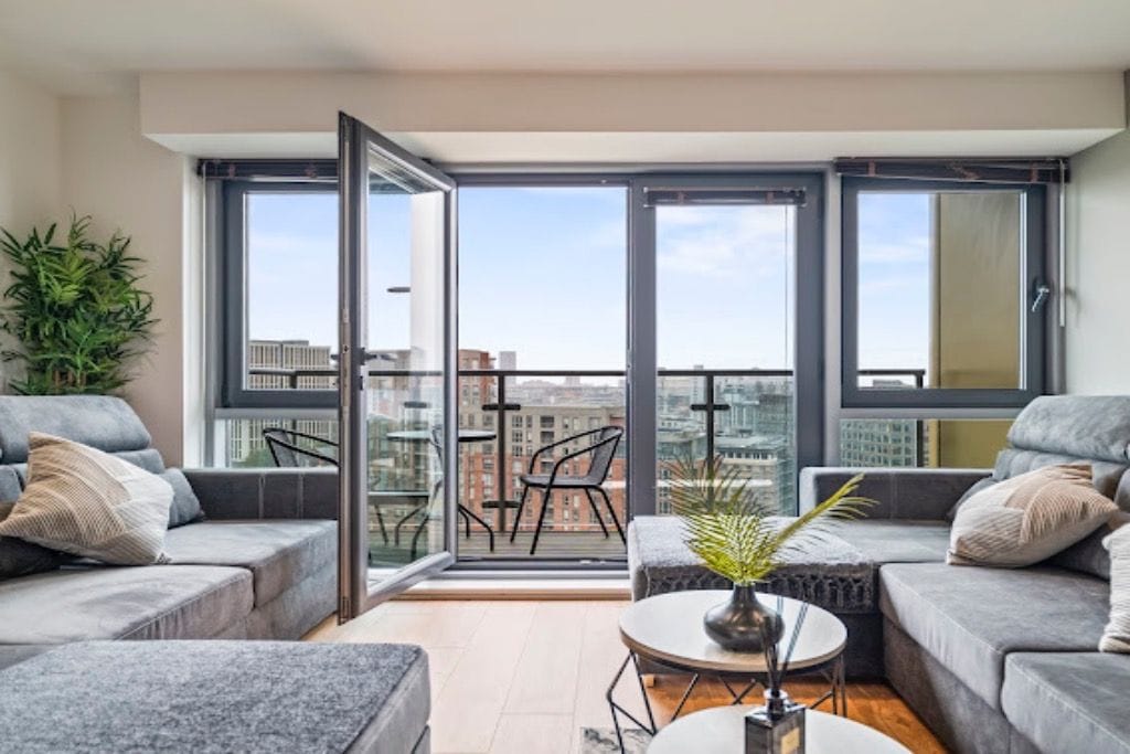 A modern living room with a sofa set, a coffee table, and a potted plant.