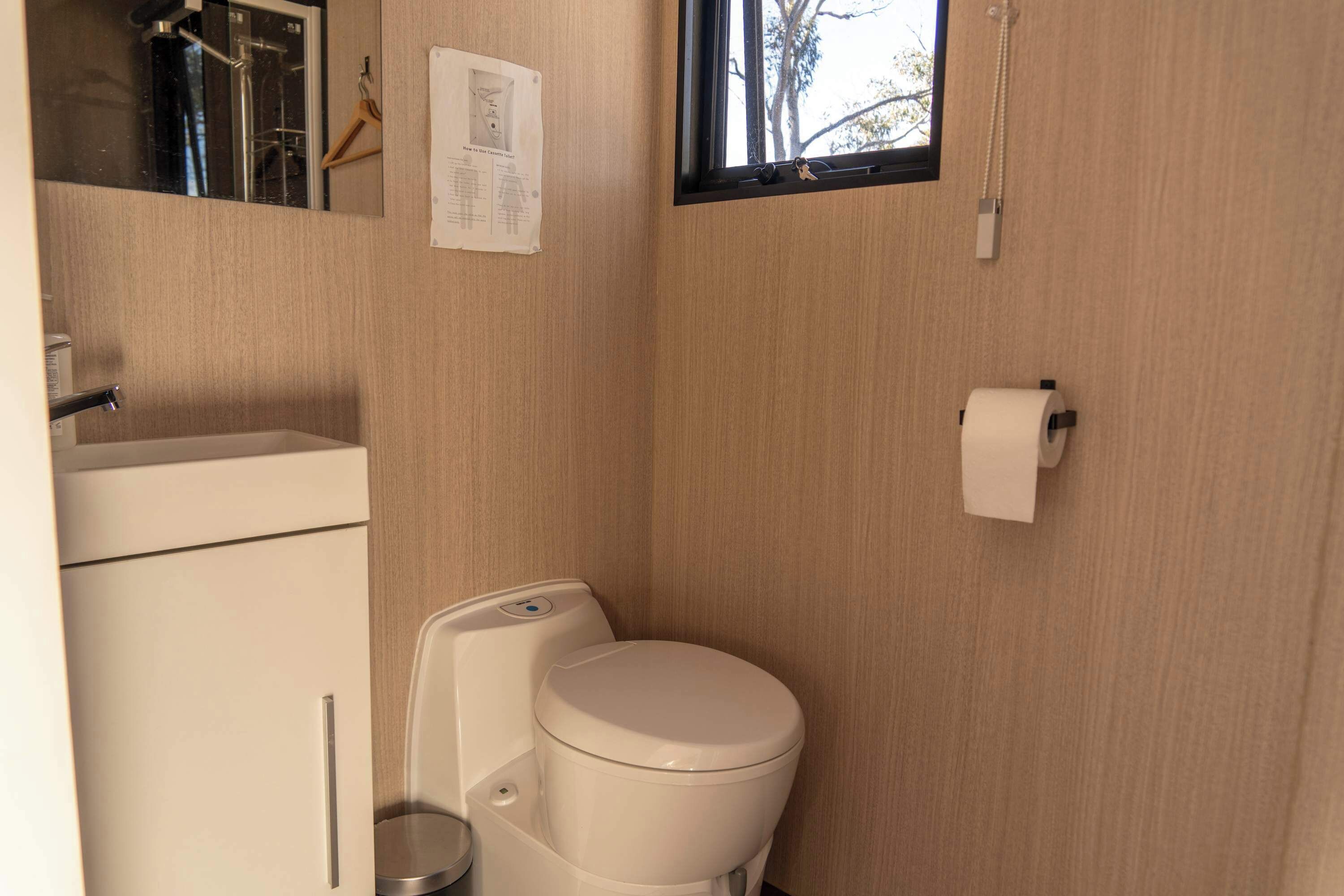 Un bagno piccolo con il water, un lavandino e una finestra.