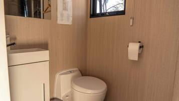 Un bagno piccolo con il water, un lavandino e una finestra.