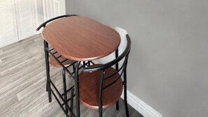A dining area with a round table and chairs, a white door, and a grey wall. - Central Hull, 3Br Contractors & Street Parking (Hull)