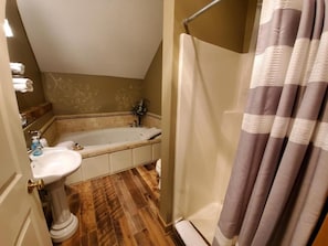 Une salle de bain avec une baignoire, un lavabo et un rideau de douche.