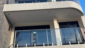 A multi-story building with a modern architectural style, featuring balconies with glass railings and a textured facade. - Adorable 2-bedroom bed & breakfast in vibrant Kigali (Kigali)