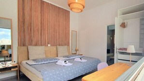 A bedroom with a bed, bedside table, lamp, and a wardrobe. - Acropolis View Apartment in Heart of Monastiraki (Athina)