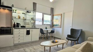 A compact living space with a kitchenette, dining area, and seating. - Acropolis View Apartment in Heart of Monastiraki (Athina)