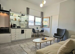 A compact living space with a kitchenette, dining area, and seating. - Acropolis View Apartment in Heart of Monastiraki (Athina)