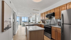 A modern kitchen with wooden cabinets, stainless steel appliances, and a large island.