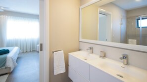 Ein Hotelzimmer mit einem Bett, einem Badezimmer mit einem großen Spiegel, einem Waschbecken und einer Toilette.